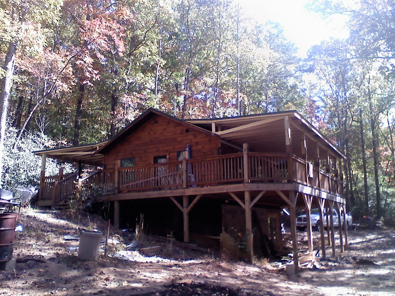 Log cabin with a wraparound porch and metal roof in the fall in Dresden